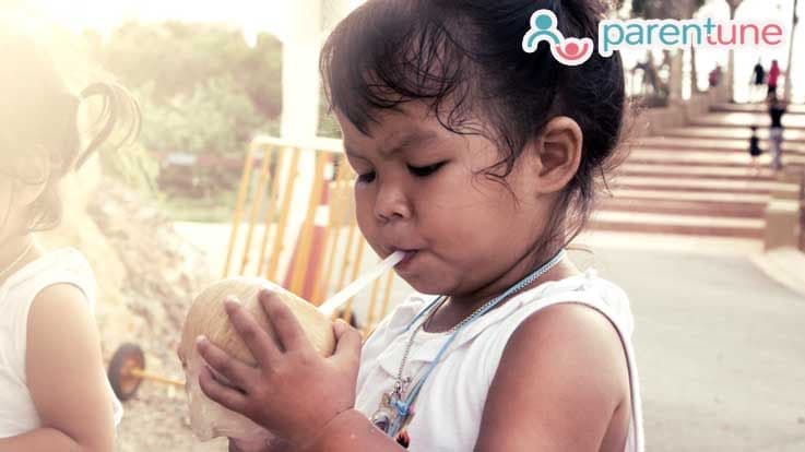 child drinking coconut water
